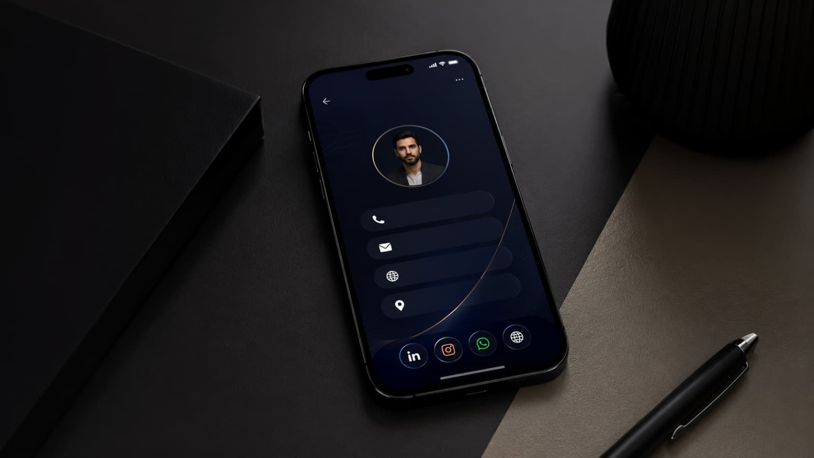 Smartphone moderno exibindo um cartão de visita digital em interface elegante com tema escuro, posicionado sobre uma mesa sofisticada em tons grafite. O ambiente minimalista conta com iluminação suave, acabamento premium e elementos corporativos discretos, transmitindo profissionalismo, tecnologia e networking digital. Ideal para representar soluções de cartão de visita digital, identidade profissional e compartilhamento de contatos online.