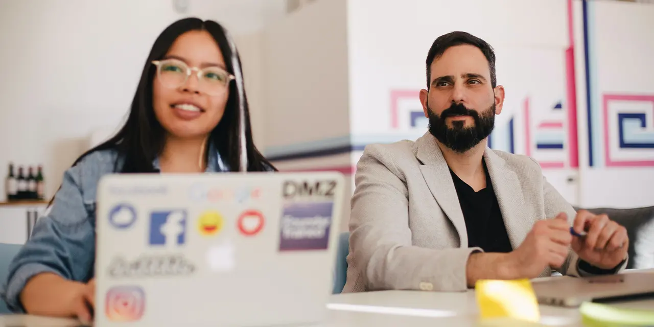 Dois profissionais assistindo à palestras de especialistas de sua área em eventos de networking